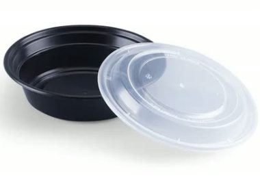 Round black takeaway bowl with a clear lid leaning against it